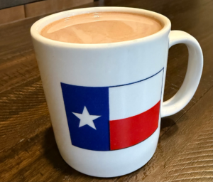 Large white mug with Dallas flag on wooden surface